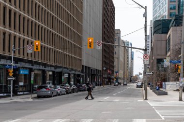 Ottawa, Kanada - 24 Nisan 2022: Şehir merkezinde kavşakta trafik ışıkları olan şehir manzarası. İnsanlar karşıdan karşıya geçiyor..