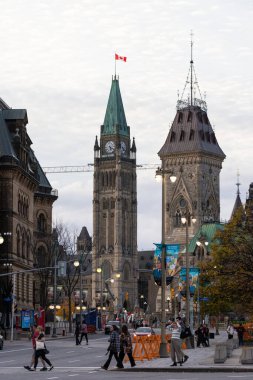 Ottawa, Kanada - 5 Kasım 2022: Kanada Parlamentosu bayraklı ve şehir merkezinde yürüyen insanlar