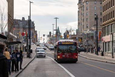 Ottawa, Kanada - 10 Kasım 2022: Şehir merkezindeki Rideau Caddesi 'ndeki otobüs. İnsanlar otobüs durağında toplu taşıma araçlarıyla yolculuk için bekliyorlar.