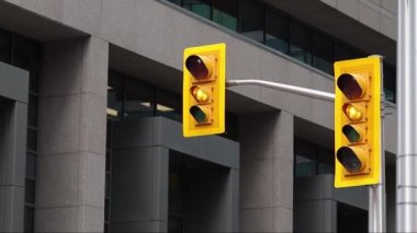 Trafik ışıkları yeşil ışıktan sarı ve kırmızı ışığa dönüyor. Kanada 'nın Ottawa şehir merkezinde binalar var.