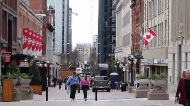 Ottawa, Kanada - 5 Kasım 2022 Sparks Caddesi. Şehrin şehir merkezinde, Kanada bayraklı ve yürüyen insanların olduğu şehir manzarası.