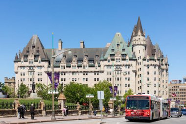 Ottawa, Kanada - 18 Mayıs 2022 Fairmont Chateau Laurier Otel binası. Şehir merkezindeki Rideau caddesinde yürüyen turistlerle dolu bir şehir manzarası. Kamu otobüsü yolda.