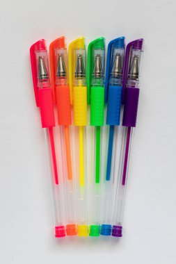 Colorful set of neon rainbow colors gel pens on white background.
