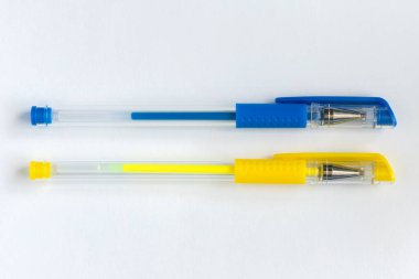 Blue and yellow gel pens on white background