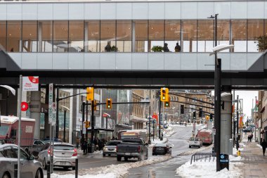 Ottawa, Canada - January 23, 2023: Rideau street with public bus stop, people walking on sidewalk and cars on road in downtown of the city