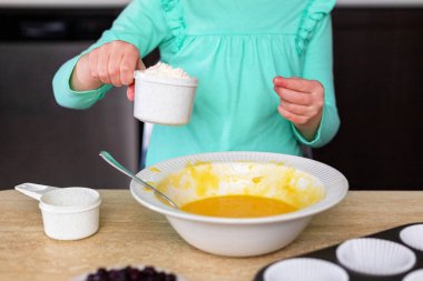 Küçük kız mutfakta para kazanıyor. Küçük çocuklar yemek yapıyor. Çocuk böğürtlenli ev yapımı kek yapıyor, yemek yapmayı öğreniyor..