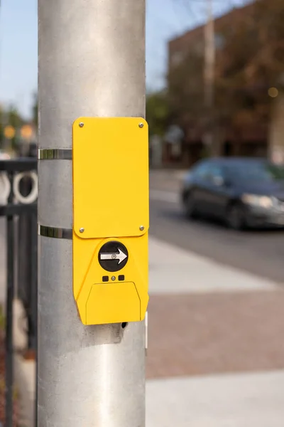 Yellow button for traffic lights for pedestrian at street crossing in the city, Canada