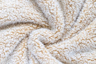 Samimi atımlardan oluşan bej yumuşak yumuşacık kumaş. Döndürülmüş sıcak battaniye arka planı.