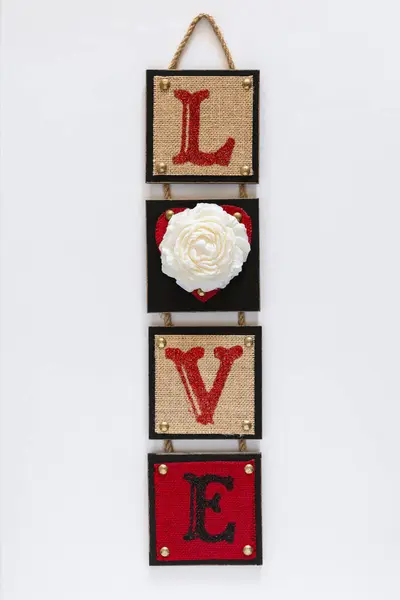 Red wall decor with word love and candle in flower shape on white background. Valentine day and love concept.