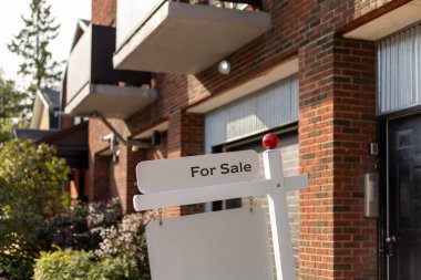 Bir yerleşim yerindeki apartman dairesinin önündeki satılık tabela için. Metin için alanı kopyala