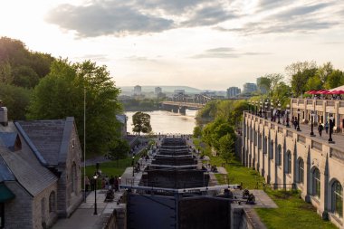 Ottawa, Kanada - 16 Mayıs 2024: Rideau kanalı şehir merkezinde kilitleniyor. Ottawa nehrinin manzarası. İnsanlar akşamları yürüyor..