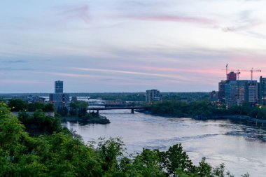 Ottawa Nehri ve Kanada 'nın iki ili arasındaki köprü Quebec ve Ontario. Akşam saatlerinde şehir manzarası