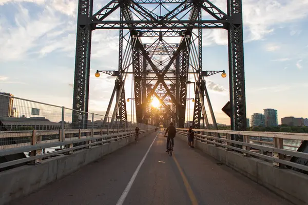 stock image Ottawa, Canada - June 4, 2024: Alexandra Bridge from Ottawa, Ontario to Gatineau city of Quebec with bikes and people on the road during sunset