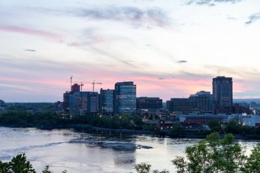 Ottawa, Kanada - 16 Mayıs 2024: Ottawa Nehri ve Kanada 'nın iki ili arasındaki köprü: Quebec ve Ontario. Akşam saatlerinde şehir manzarası