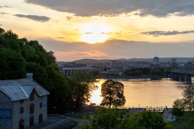 Ottawa, Kanada - 16 Mayıs 2024: Rideau kanalı gün batımında Ottawa Nehri 'ni kapatır.