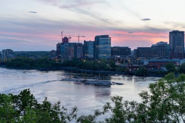 Ottawa, Kanada - 16 Mayıs 2024: Ottawa Nehri ve Kanada 'nın iki ili arasındaki köprü: Quebec ve Ontario. Akşam saatlerinde şehir manzarası
