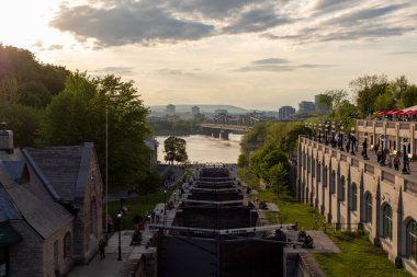 Ottawa, Kanada - 16 Mayıs 2024: Rideau kanalı şehir merkezinde kilitleniyor. Ottawa nehrinin manzarası. İnsanlar akşamları yürüyor..