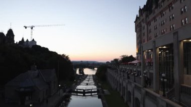 Ottawa, Kanada - 31 Ağustos 2024: Ottawa, Kanada 'da Rideau kanal kilitleri. Ottawa nehri manzaralı, Alexandra köprüsü ve oteli şehir merkezinde gün batımında.