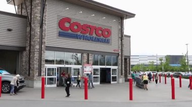 Ottawa, Kanada - 8 Haziran 2024: Costco Toptan Binası ve insanlar alışveriş arabalarıyla mağazadan çıkıyorlar.