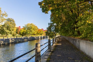 Sonbahar mevsiminde Kanada 'nın Ottawa kentindeki Rideau Kanalı' nda sonbahar yaprakları ve huzurlu bir patika bulunur..