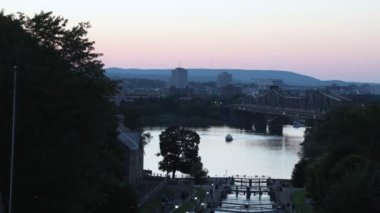 Ottawa, Kanada - 31 Ağustos 2024: Ottawa, Kanada 'da Rideau kanal kilitleri. Ottawa nehri, Alexandra köprüsü ve oteli gün batımında şehir merkezinde. Yelkenli tekne