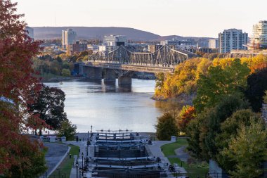 Rideau kanal kilitleri ve sonbaharda Ottawa nehri. Kanada 'daki Alexandra Köprüsü ve Gatineau şehri Quebec' e bak.