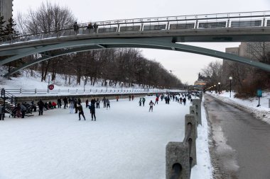 Ottawa, Kanada - 8 Şubat 2025: İnsanlar Rideau Kanalı 'nda kış aylarında köprünün altında paten kayıyorlar.