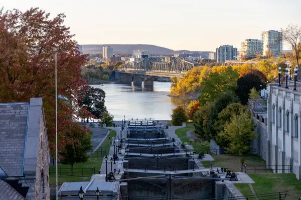 Rideau kanal kilitleri ve sonbaharda Ottawa nehri. Kanada 'daki Alexandra Köprüsü ve Gatineau şehri Quebec' e bak.