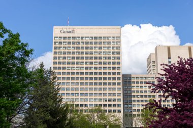 Ottawa, Kanada - 16 Mayıs 2024: İlkbaharda çiçek açan ağaçla birlikte şehir merkezinde hükümet binası. Ulusal Savunma Karargahı, Kuzey Kulesi, NDHQ.
