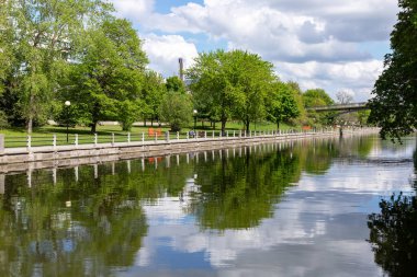 Ottawa, Kanada - 16 Mayıs 2024: Rideau Kanalı ve bisiklet yolu ilkbaharda kıyı şeridi boyunca. Bisiklet yolu olan bir park..