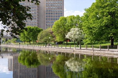 Ottawa, Kanada - 16 Mayıs 2024: Rideau Kanalı ve bisiklet yolu ilkbaharda kıyı şeridi boyunca. Şehir merkezinde bisiklet yolu olan bir park..