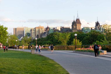 Ottawa, Kanada - 16 Mayıs 2024: Major 's Hill Park, şehir merkezinde. İnsanlar ilkbaharda parkta yürürler. Parlamento binası