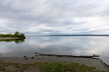 Bulutlu bir günde gökyüzü ve nehir kıyısı. Yazın Riverside