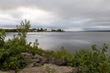 Gün batımında nehir kıyısında. Rıhtım manzarası ve yazın ufuk çizgisi. Ottawa Nehri Kanada 'daki Andrew Haydon Parkı.