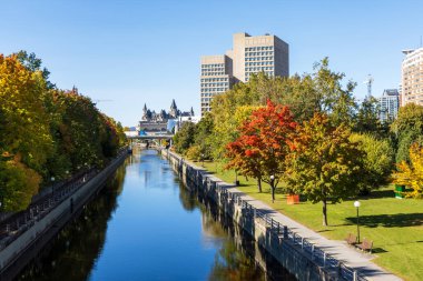 Ottawa, Kanada - 17 Ekim 2024: Sonbahar sezonu boyunca şehir merkezinde Rideau Kanalı. Sonbaharda yeşillikli şehir manzarası.