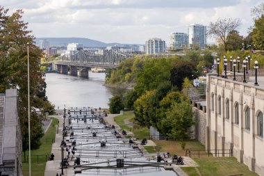 Ottawa, Kanada - 1 Ekim 2024: Ottawa, Kanada sonbahar sezonunda Rideau kanal kilitleri. Ottawa nehri, Alexandra köprüsü ve Quebec Gatineau şehri.