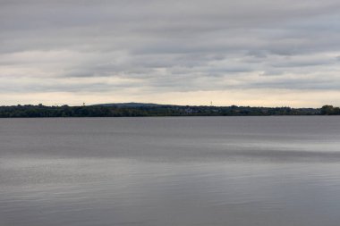 Gün batımında bulutlu gökyüzü ve nehir. Kanada 'da Ottawa Nehri