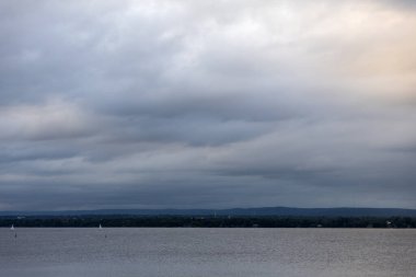Gün batımında bulutlu gökyüzü ve nehir. Kanada 'da Ottawa Nehri