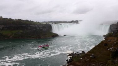 Ontario, Kanada 'da bulutlu bir günde Niagara Şelalesi' nde tur teknesi