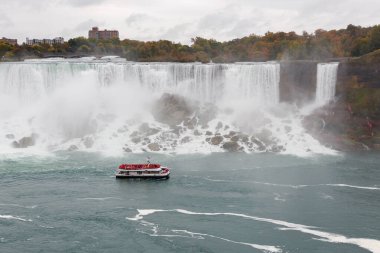 Niagara Şelalesi ve Kanada, Ontario 'da insanlarla dolu bir tur teknesi. Amerikan Şelalesi