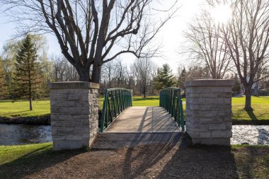 İlkbaharda şehir parkındaki bir derenin üzerindeki köprü. Stewart Park Perth, Ontario, Kanada.