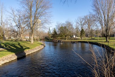 Stewart Park Perth, Ontario, Kanada. Güneşli bir bahar gününde küçük bir nehri olan şehir parkı.