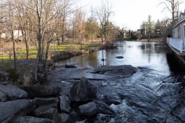 Baharda bir dere ve kaya oluşumları olan şehir parkı. Stewart Park Perth, Ontario, Kanada.