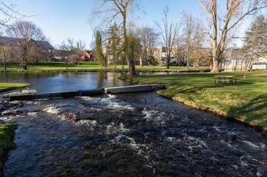 Baharda deresi ve piknik masası olan şehir parkı. Stewart Park Perth, Ontario, Kanada.