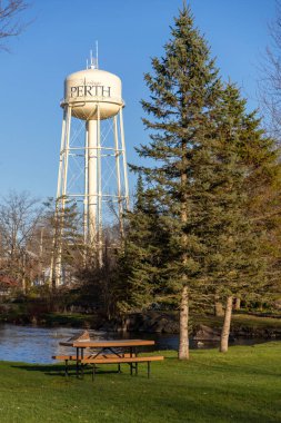 Perth, Kanada - 27 Nisan 2025: Bahar mevsiminde Ontario 'da küçük bir kasabada piknik masası ve su kulesi olan park.