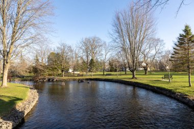 Stewart Park Perth, Ontario, Kanada. Güneşli bir bahar gününde küçük bir nehri olan şehir parkı.
