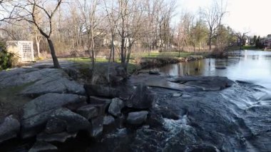 Baharda bir dere ve kaya oluşumları olan şehir parkı. Stewart Park Perth, Ontario, Kanada.