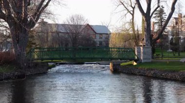 İlkbaharda dere üzerinde küçük bir yaya köprüsü. Stewart Park Perth, Ontario, Kanada.