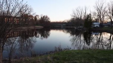 Baharda Perth, Ontario, Kanada 'da manzara. Gün batımında nehir kıyısı sudaki ağaçların yansımalarıyla.