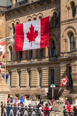 Kanada, Ottawa - 1 Temmuz 2024: Kanada Günü şehir merkezinde. Başbakanlık ve Danışma Kurulu binasında Kanada bayrakları var. Wellington caddesinde yürüyen insanlar
